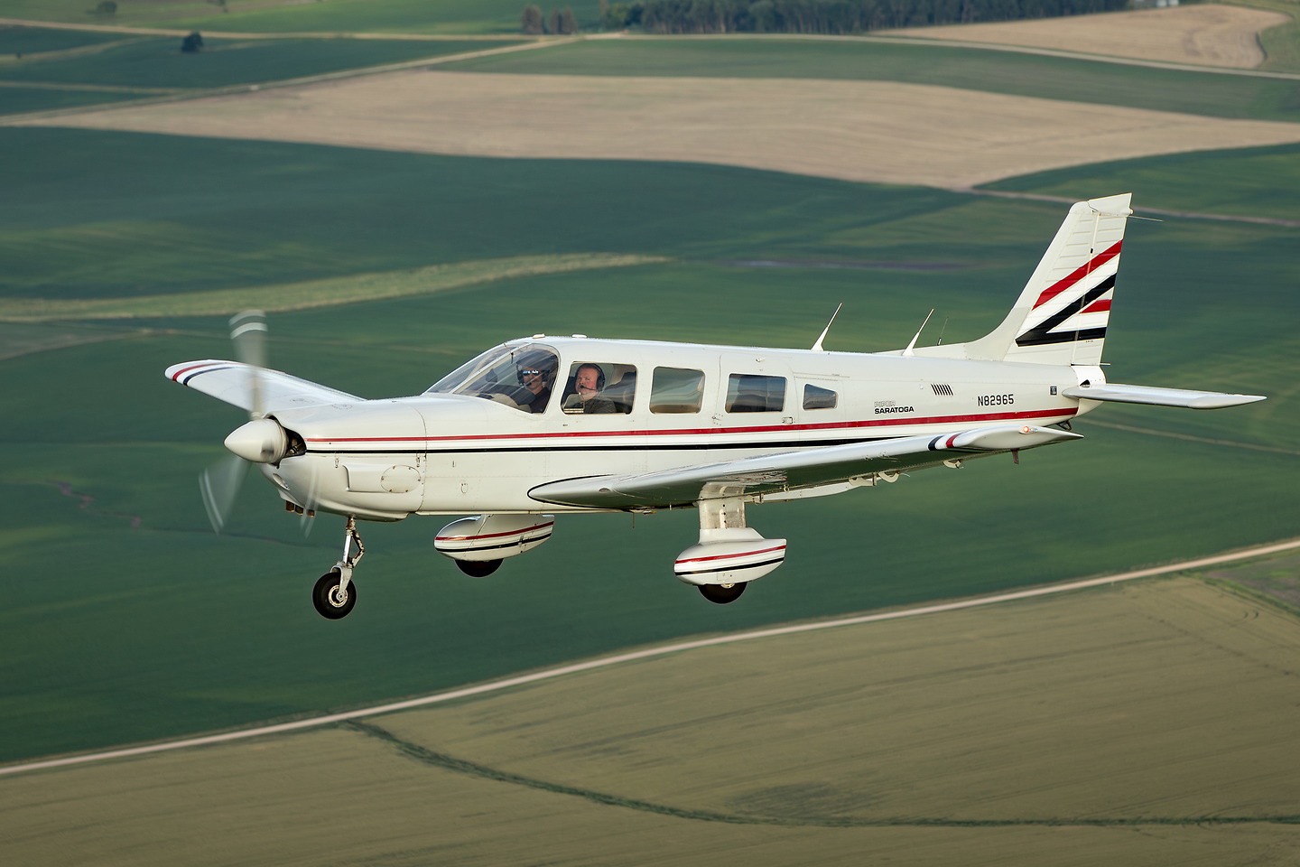Piper Saratoga N82965 flying over farmland